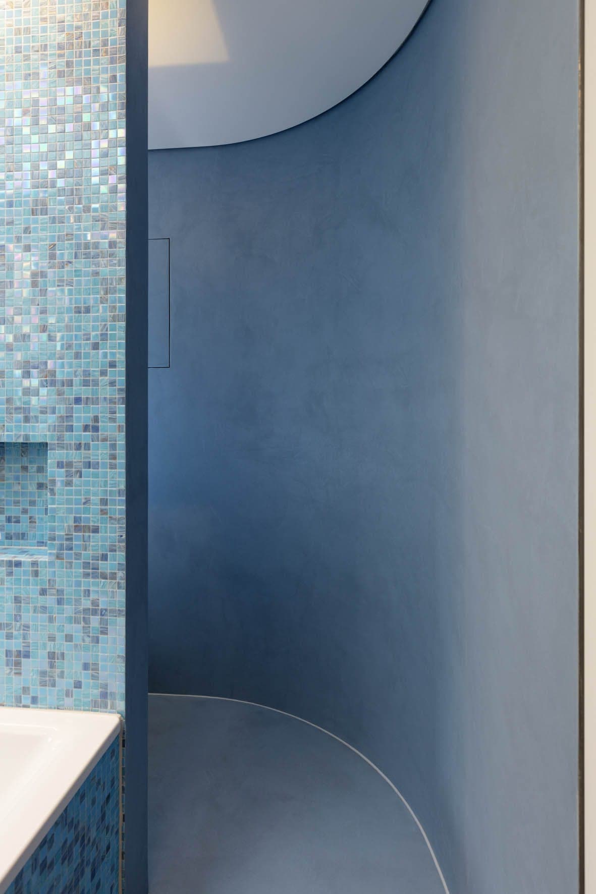 Eingang zu einer runden Duschkabine mit blauen Wänden