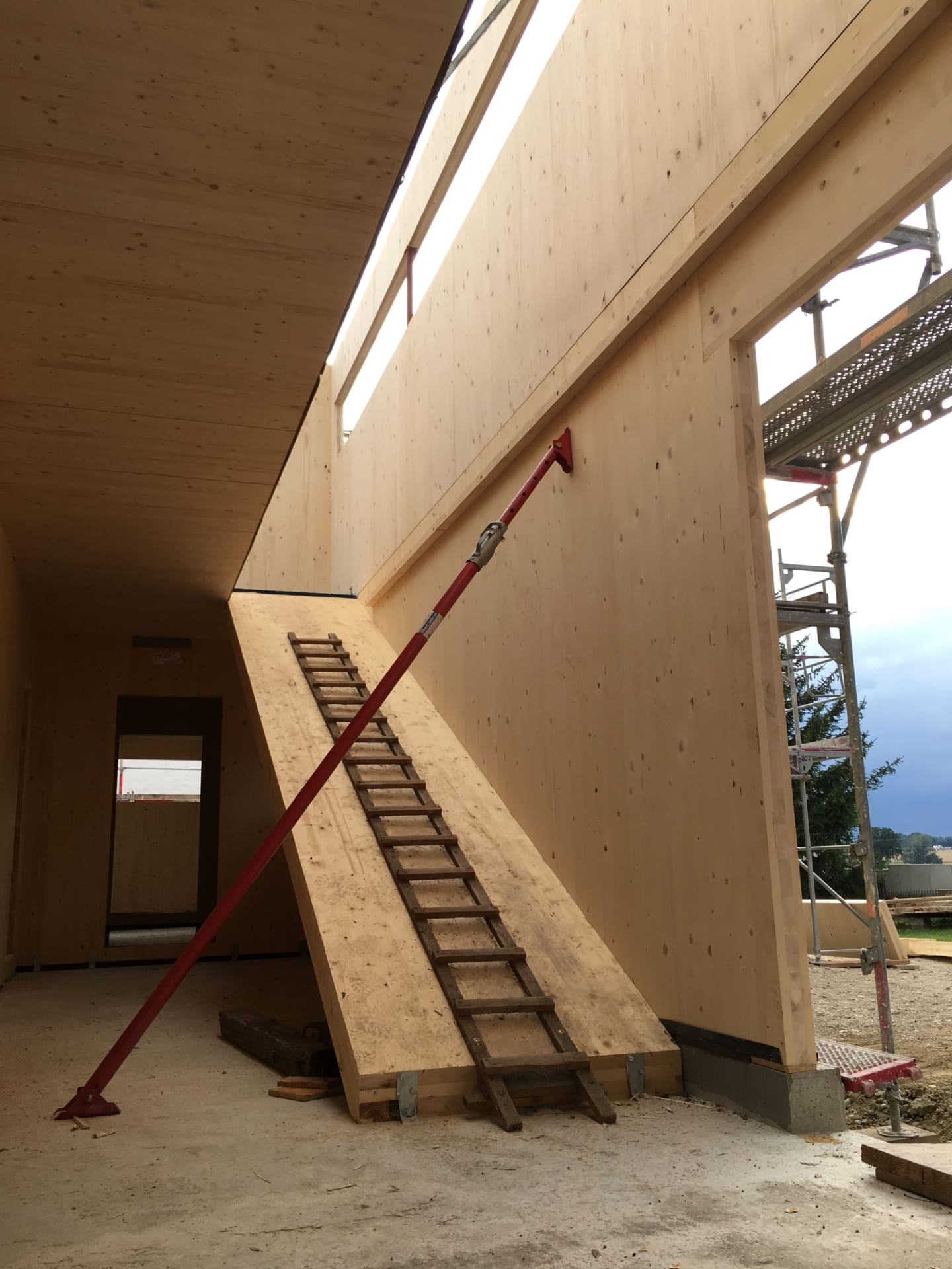 Holzleiter als Treppenersatz ins Obergeschoss eines Einfamilienhauses aus Massivholz während der Bauphase