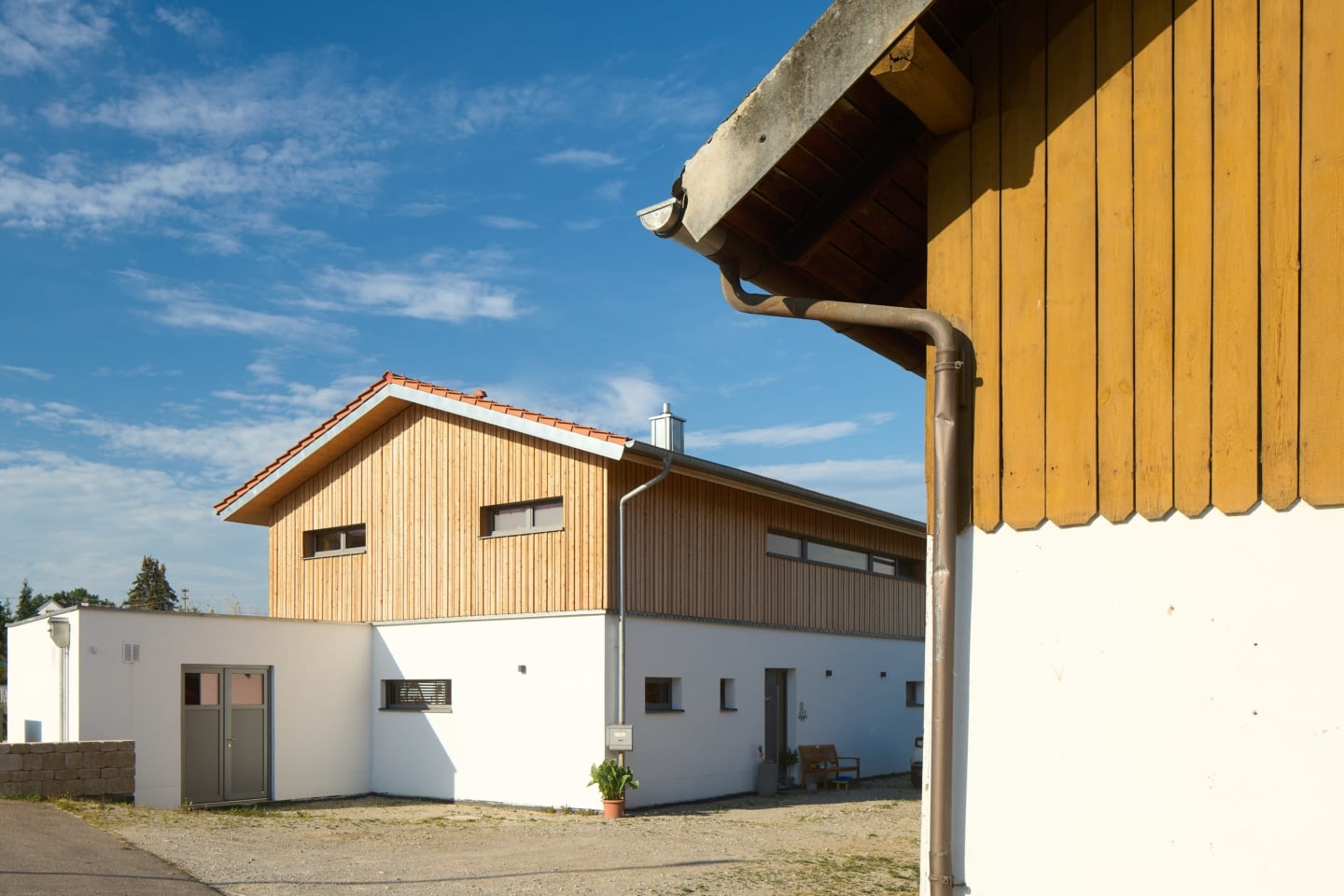 Neues Haus mit Putz- und Lärchenholzfassade auf einer großen Hofstelle