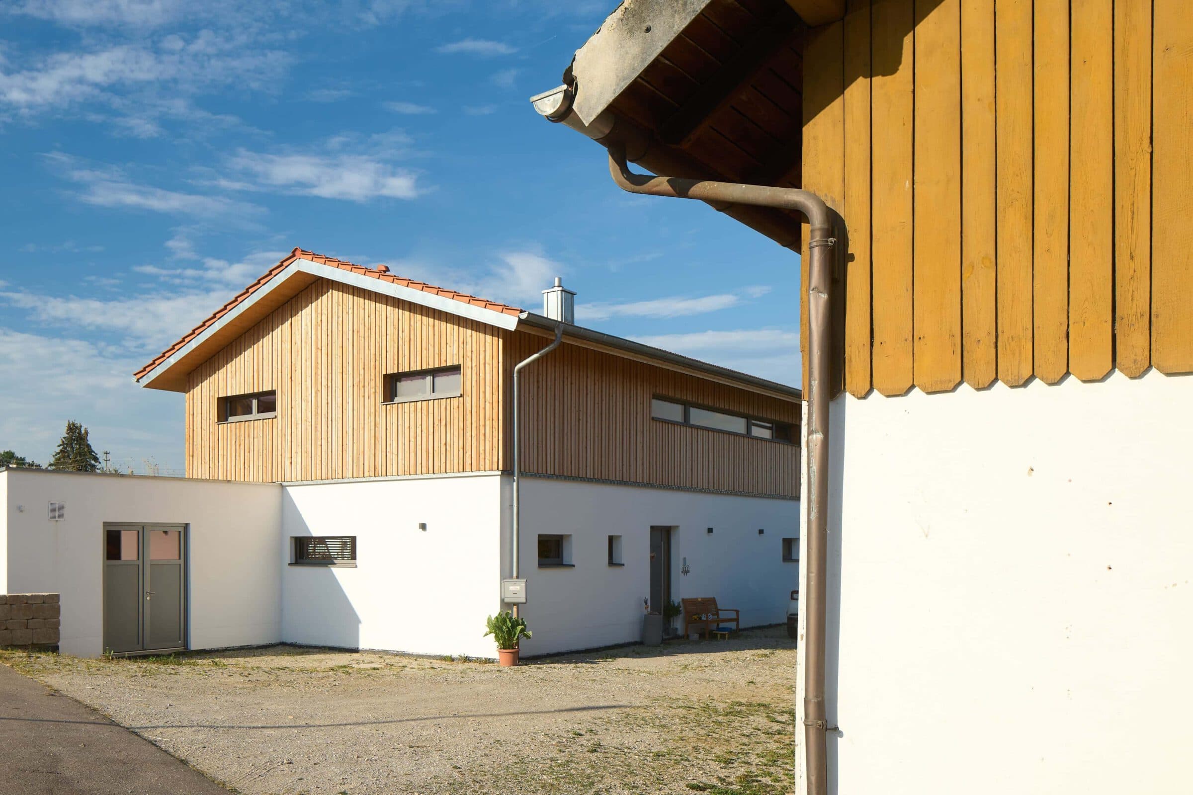 Neues Haus mit Putz- und Lärchenholzfassade auf einer großen Hofstelle