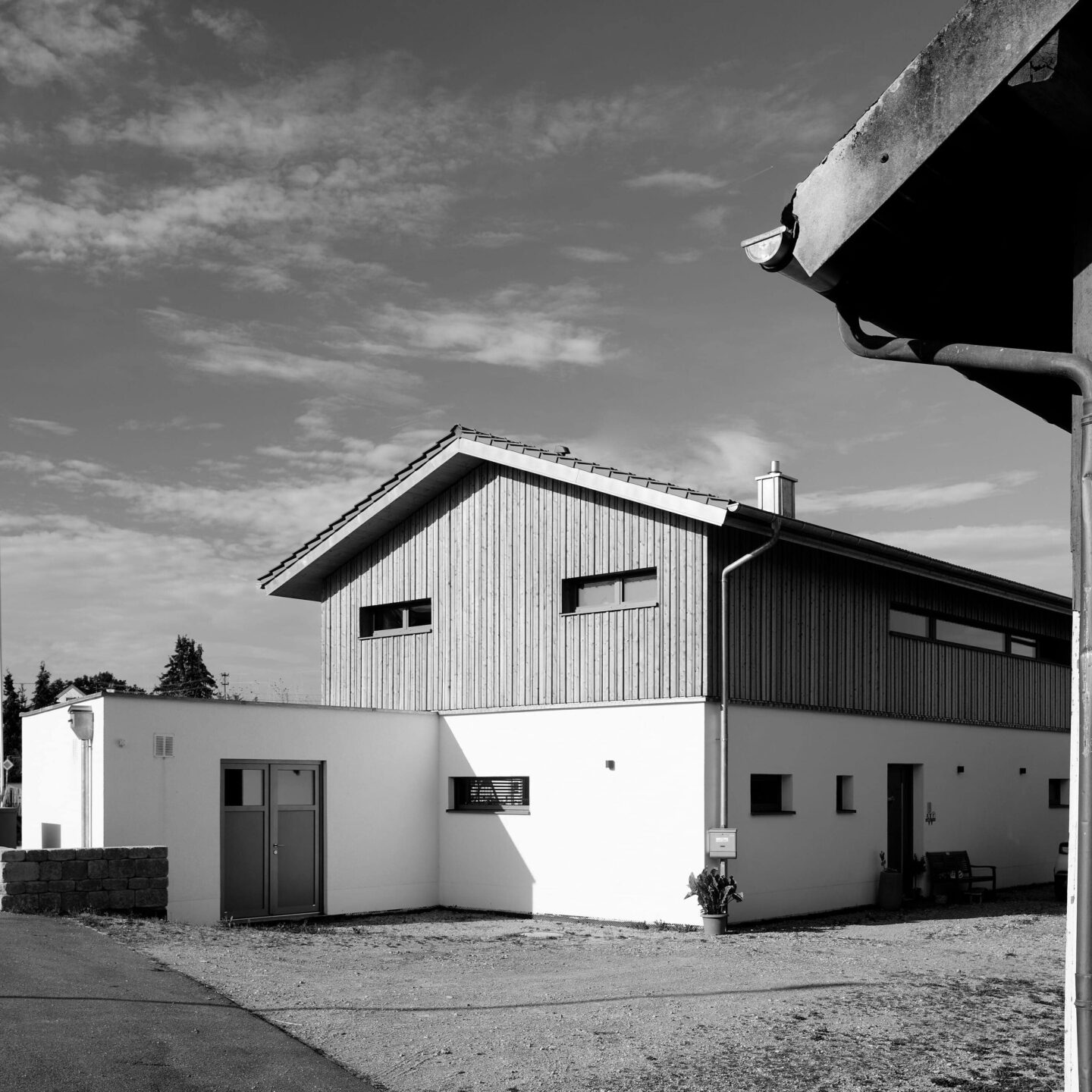 schwarz weiß Bild eines neuen Hauses auf einer alten Hofstelle