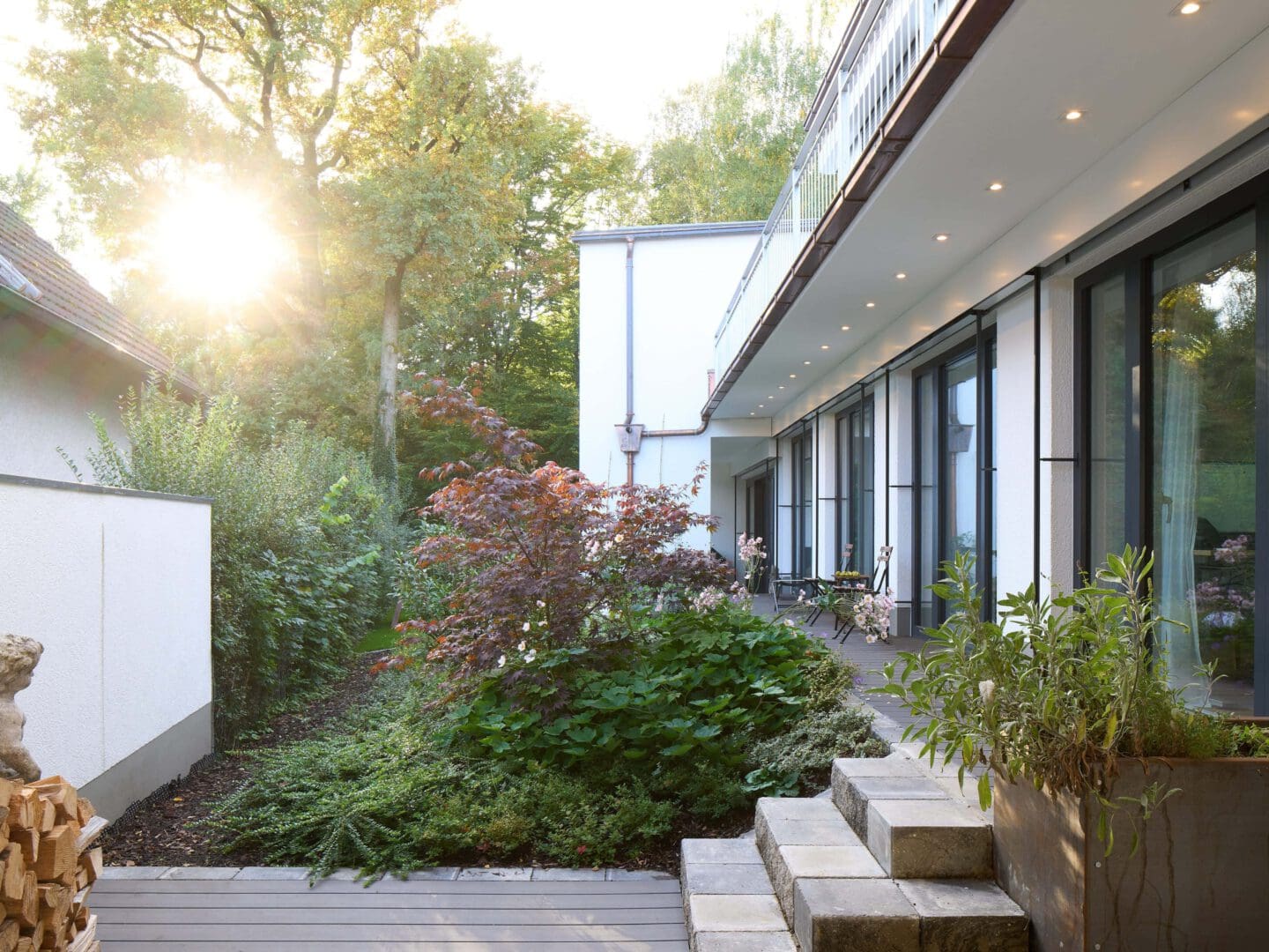 Blick in einen dicht bewachsenen Garten eines umgebauten Einfamilienhauses