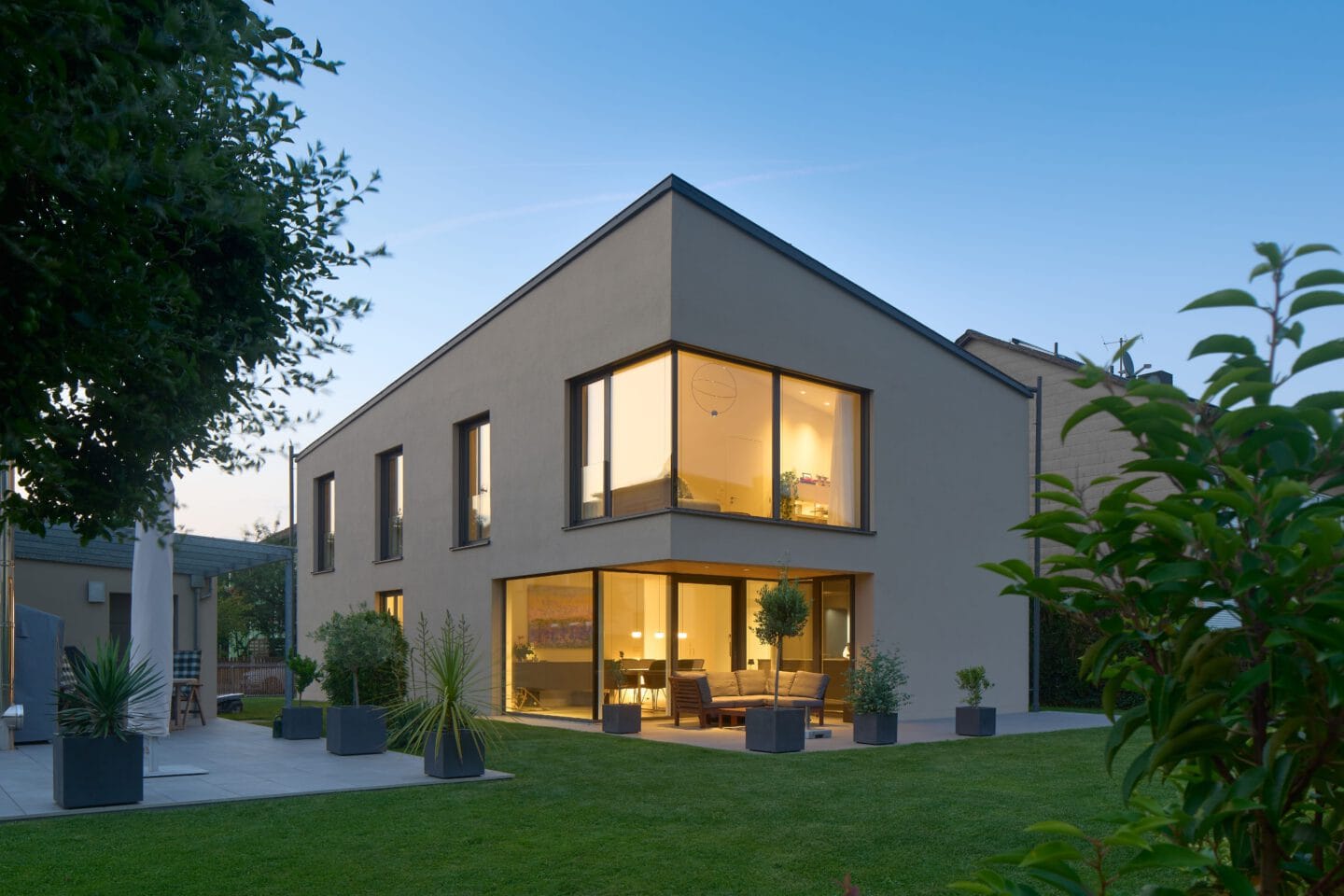 Einfamilienhaus mit besonderer Dachform und Garten Dämmerung